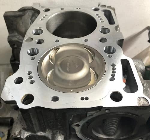 Close decked Subaru EJ case half with a forged piston at the top of the bore